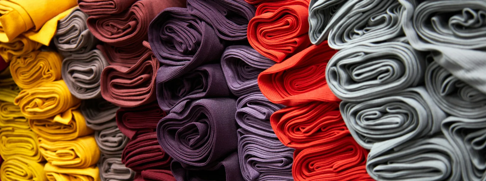 Stofe textile colorate stivuite — materiale pentru halate și uniforme personalizate